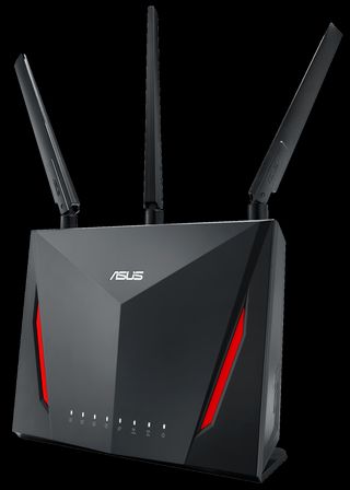 A futuristic black router with red stripes, 8 LEDs, 3 antennae and an “ASUS” logo sitting above a raised angled point on the front.